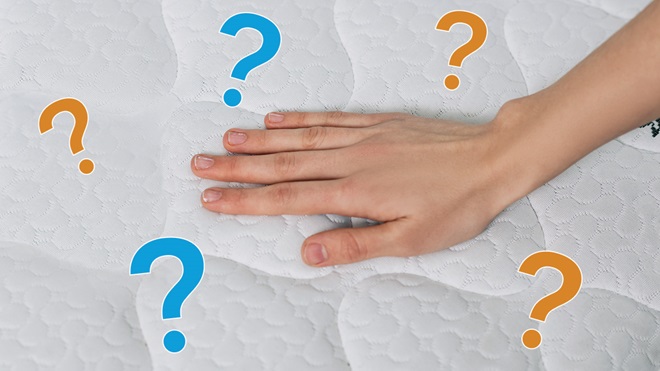 person using hand to test firmness of mattress